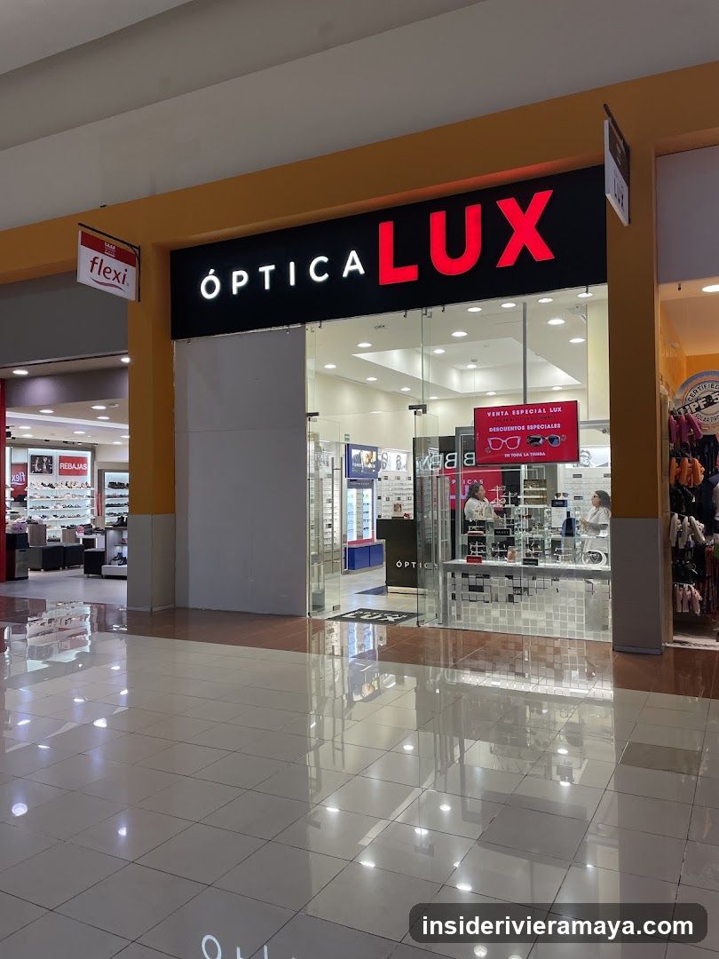 A storefront for an optical shop named 'ÓPTICA LUX' with a large black sign featuring white and red lettering. The entrance consists of glass doors and windows, revealing a brightly lit interior with display cases and eyewear. A red promotional sign is visible inside the window, and a hanging 'flexi' sign is attached to the building's facade.