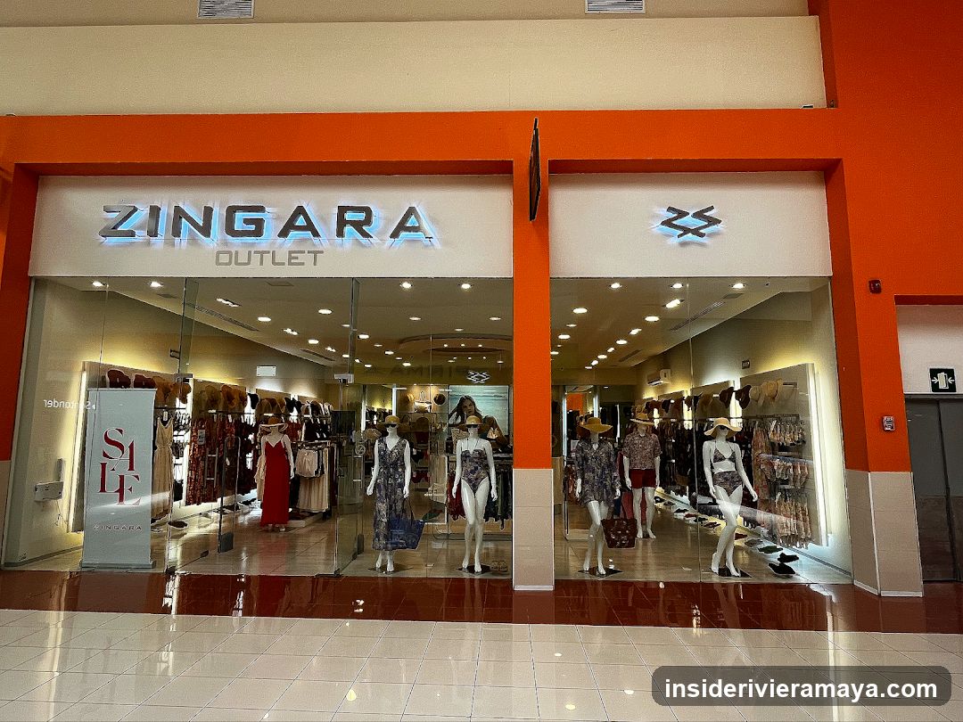 A wide shot of a retail store entrance with bright orange framing. The sign reads 'ZINGARA OUTLET' in large silver letters. The store features large glass windows and doors, displaying several mannequins dressed in summer clothing, including swimsuits and dresses. A vertical 'SALE' sign is visible inside the left window.